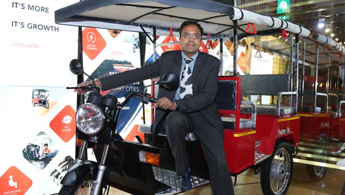 Ayush Lohia with the latest electric rickshaw displayed at Lohia Auto's stall at EV Expo 2015